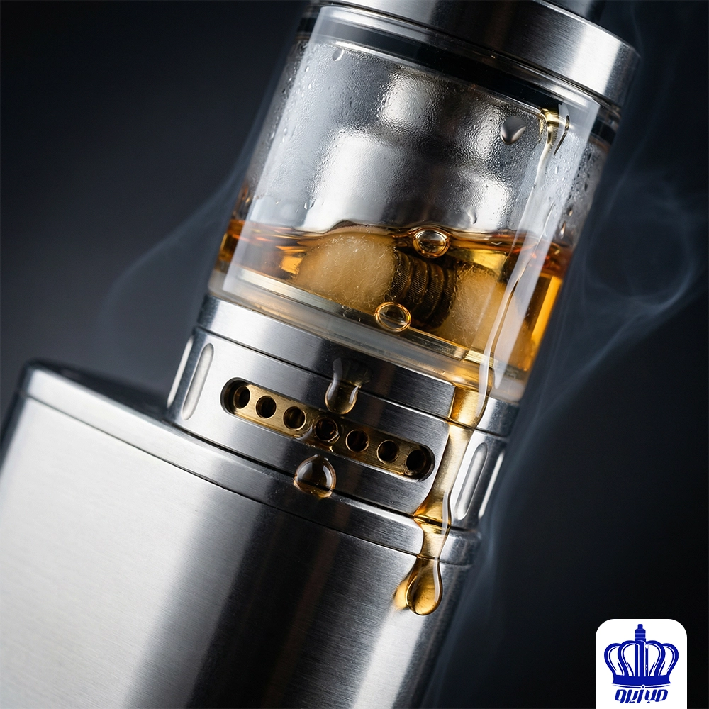 لقطة مقربة لرأس تانك فيب صب زيرو معدني به سائل النكهة البني يتسرب ويقطر من فتحات الهواء، مع أبخرة في الخلفية.